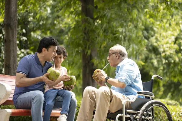 Erkek hindistan cevizi suyu içiyor ve parkta eğleniyor.