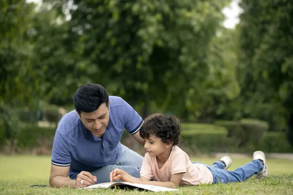 Baba ve oğlunun resmi. Resmi pastel boyayla boyuyorlar.