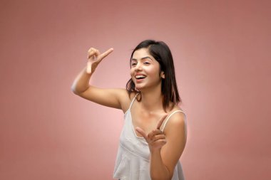 Tatlı bir kadın kameraya doğru nazik bir gülümsemeyle poz verir.