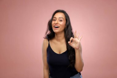 İnanılmaz bir kadın gülümsüyor ve elleriyle iyi bir jest yapıyor.