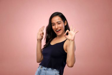 Siyah bluzlu havalı kadın ellerini kaldırıp gülümsüyor.