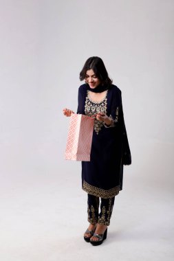 Alışveriş torbalarının içine bakan kadın manken resmi. Şaşırmış bir ifade.