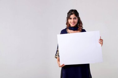 Şaşırmış bir ifadeyle genç seksi bir kadın terfi metni için elinde boş bir beyaz tahta tutuyor. Promosyon, iş, reklam, afiş kavramı