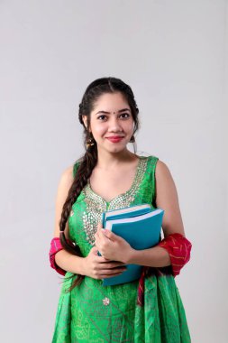 Elinde kitaplarla gülümseyen, keskin bir kadının yakın çekim görüntüsü.