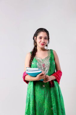 Üniversite 'nin portresi Kırmızı ve Yeşil Salwar Kameez takım elbiseli mükemmel öğrenci gri arka planda kitapları elinde tutuyor