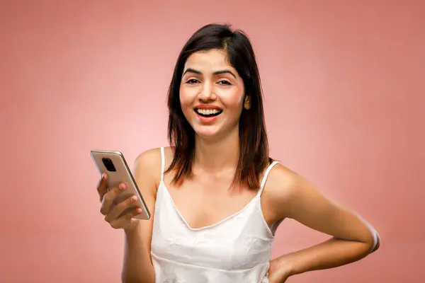 Gülümserken akıllı telefonunu kullanan güzel bir kadın.