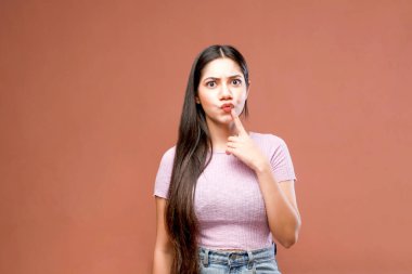 Kameraya poz verirken ve pembe arka planda dururken çok güzel bir model.