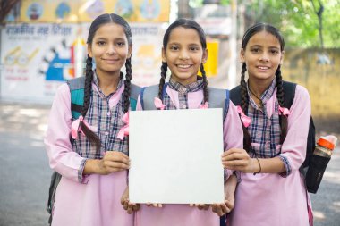 Okul üniformalı üç Buddy 'nin elinde beyaz boş kağıt var.