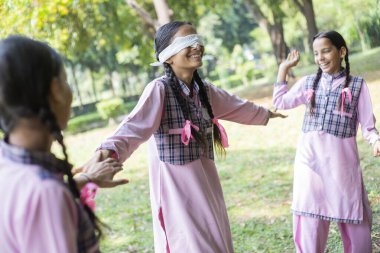 Okul parkında oyun oynarken gülen kız arkadaşlar