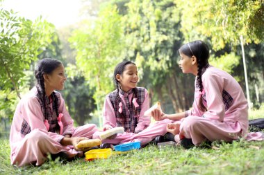 School Girls eating lunch during recess time at school clipart