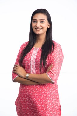 Güzel, gülümseyen bir kadın kollarını kavuşturup beyaz arka planda kameraya bakıyor.