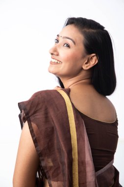 Kahverengi sarili bir mankenin fotoğrafı yan bakarken gülümsüyor.