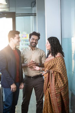 Yarı daire içinde duran ve iş problemlerini tartışan kurumsal profesyoneller.