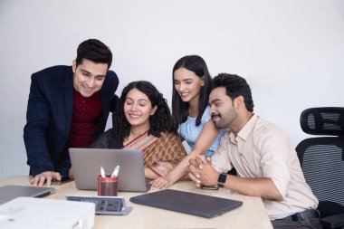 Ofiste dizüstü bilgisayarla çalışan bir grup insan.