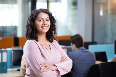 Kurumsal kadın ofiste duruyor.