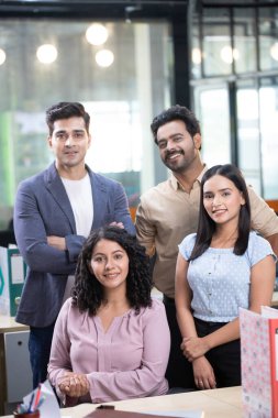 Genç iş adamları kameraya bakarken gülümsüyor ve poz veriyorlar.