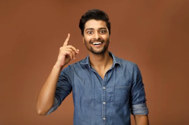 Heyecanlı bir adam gülümseyen bir yüzle kameraya bakarken 