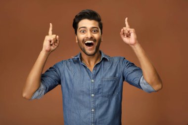 Zaferi kutlamak için ellerini kaldıran ve yumruklarını sıkan mutlu bir erkek mankenin yakın çekimi.