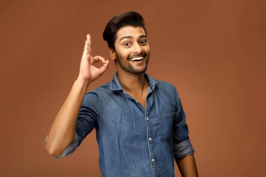 Çekici bir genç adam kameranın önünde poz verirken 