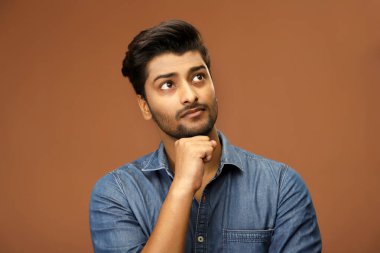 Bir adam eli çenesinin altında bir şey düşünüyor.