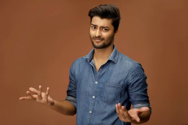 Kot gömlek giymiş, elleri havada, yüzü başı karışmış bir adam.