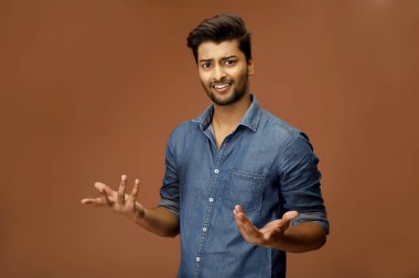 Kafası karışmış bir adam omuz silkiyor.