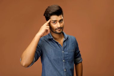 Asyalı bir manken parmağını kafasında tutarken bir şeyler düşünüyor.