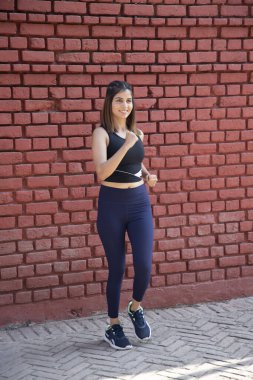 Aktif giyimli atletik kadın dışarıda yürüyüş yapıyor.