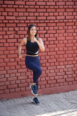 Aktif kıyafetli hoş bir kız dışarıda yürüyüş yapıyor.