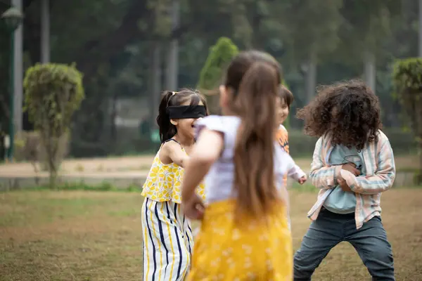 Anaokulu çocukları gözbağı oyununun keyfini çıkarıyorlar.