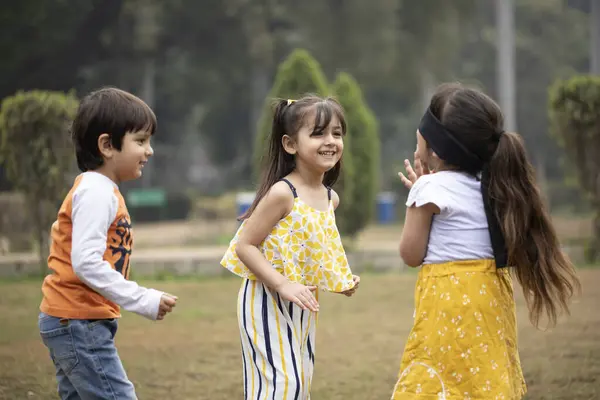 Uzun saçlı kız parkta saklambaç oynuyor.