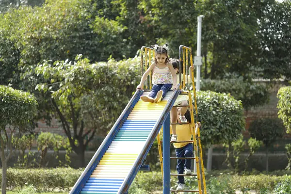 Oyun parkında oynayan 3 çocuk sürgüde kayıyor