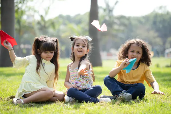 Hintli çocuklar kağıt uçakla oynuyorlar.