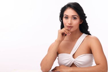 Zarif bir kadın zarif ve sofistike bir ifadeyle poz verir. Parlak bir şekilde makyajını ve tarzını ön plana çıkarır..