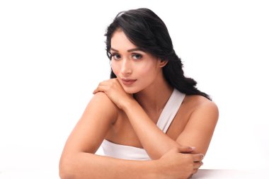 Tek Omuzlu Beyaz Üstlü Şık Kadın Güzellik ve Moda İçin Minimalist Bir Arkaplan Karşısında Zarifçe Pozisyon Veriyor.