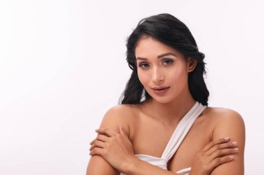 Güzel bir kadın kameraya özgüvenle bakar ve yumuşak saçları zarif özelliklerini çerçeveler..