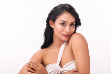 Zarif bir model, dengeli bir duruş sergilerken, güzellik ve kendine bakım uygulamalarını vurgularken, cilt bakımı rutinini gösterir..