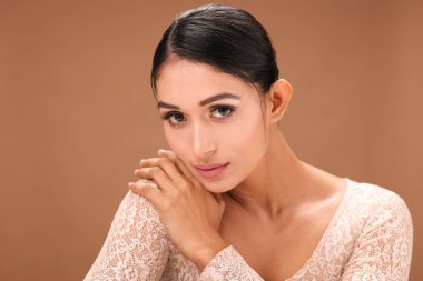 Şık makyajlı, çarpıcı özellikleri ve kendine güveni olan genç, güzel bir kadın..