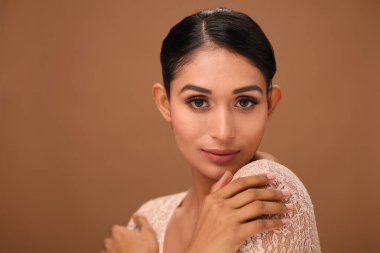 Zarif bir model makyajsız görünüşünü sergilerken aynı zamanda kendini kabullenme ve bir stüdyoda minimalist güzellik yaklaşımını tanıtıyor..