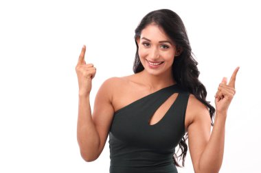 Mutlu bir kadın heyecanlı bir şekilde iki parmağı da yukarı kaldırarak önemli bir şeye dikkat çeker. Terfi, duyuru ya da teşvik edici eylemler gibi kavramlar.