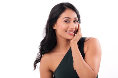 Bir dişi, beyaz bir arka planda kameraya bakarken bir eliyle poz verir. Kendine güveni bunu güzellik, moda ve yaşam tarzı kavramları için mükemmel kılıyor..