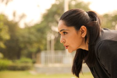 Yoğun bir egzersiz yapan bir kadının yakın plan görüntüsü. Güç ve enerjiyle egzersiz yaparken azmini ve odaklanmasını gösteriyor..