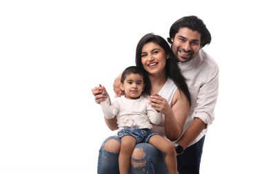 Ebeveynler mutlu bir şekilde küçük çocuklarıyla poz verirler, neşeli bir ortamda sevgi dolu bir aile anısı yaratırlar..