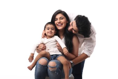 Bir aile, merkezinde oturan ve gülen küçük bir çocukla neşeyle etkileşim halindedir..