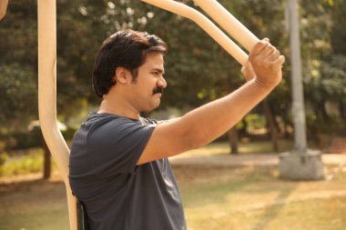 Parktaki bir spor salonunda spor yapan genç aktif bir adam sağlıklı bir yaşam tarzı için spor yapıyor..