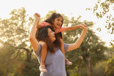 Parktaki mutlu anne ve kız açık hava ortamında birlikte güzel vakit geçiriyorlar..
