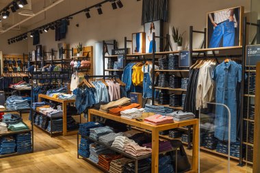 Londra 'daki Levis mağazasının içinde düzenli kot pantolon sergileri, raflar ve canlı bir perakende ortamı var. Londra, İngiltere, 19 Mayıs 2023