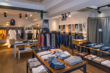 Şık bir iç giyim mağazası katlanmış moda kıyafetleri, modern raflar ve canlı ışıklandırma. Londra, İngiltere, 21 Mayıs 2023