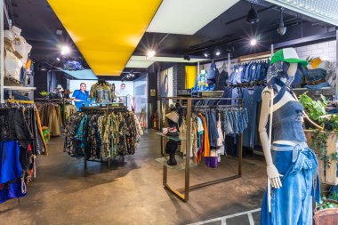 Renkli giysiler, mankenler ve modaya uygun iç dekorasyonlar satan şık bir moda mağazası. Londra, İngiltere, 21 Mayıs 2023