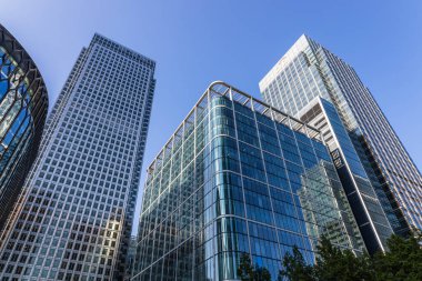 Discover the bold architecture of London Canary Wharf skyscrapers with their stunning glass facades. London, UK, 4 June 2023 clipart